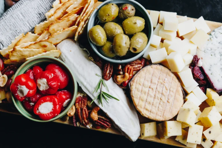 Borrelplank met kaasblokjes, olijven en gevulde paprika's