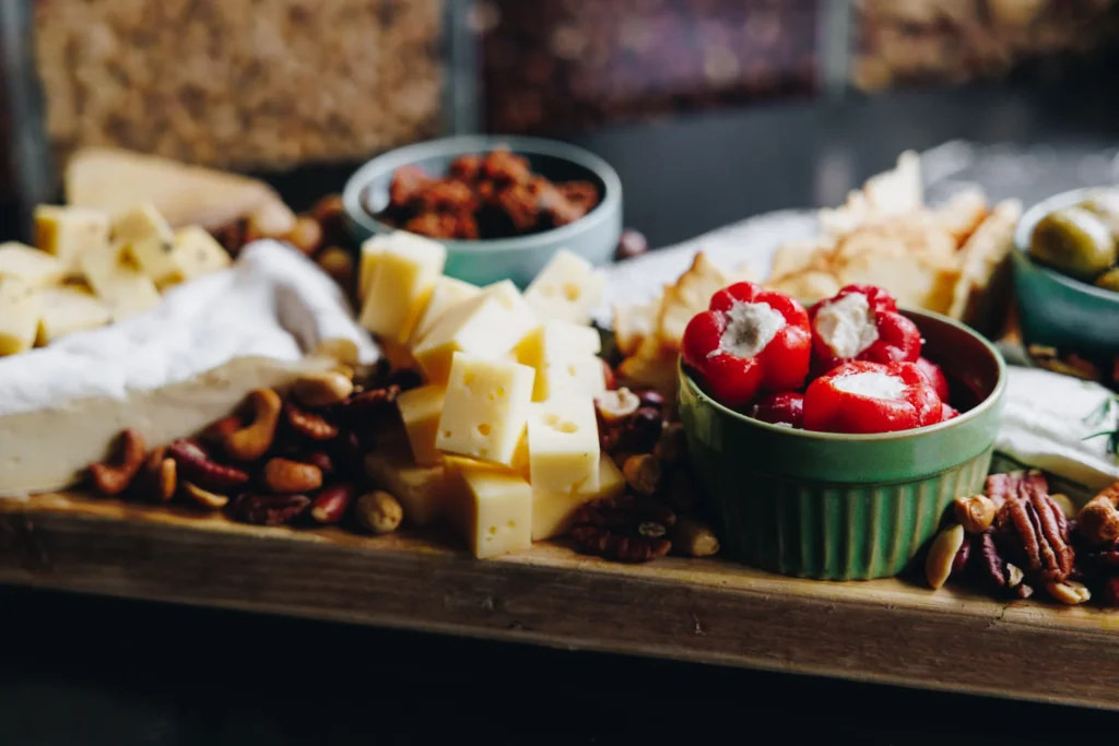 Borrelplank met kaasblokjes, gevulde paprika's en olijven