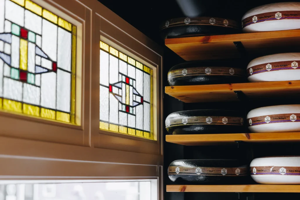 Glas-in-loodramen met kaaswielen op de plank